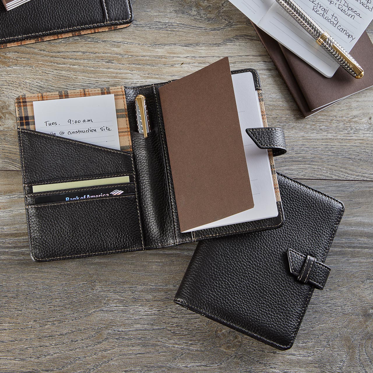 A Circa Softolio open on a café table with a Junior Circa notebook, pen, phone, and boarding pass neatly organized.