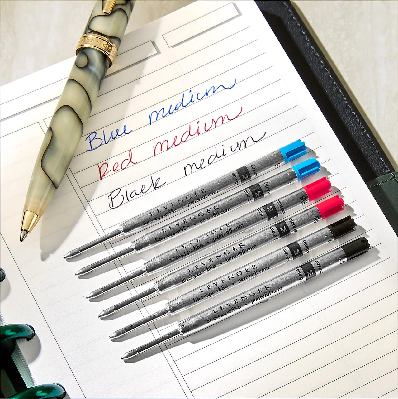 A close-up of a fountain pen nib writing on smooth paper, with droplets of ink and a cleaning bulb nearby, suggesting diagnostics for skips, hard starts, and scratchiness.