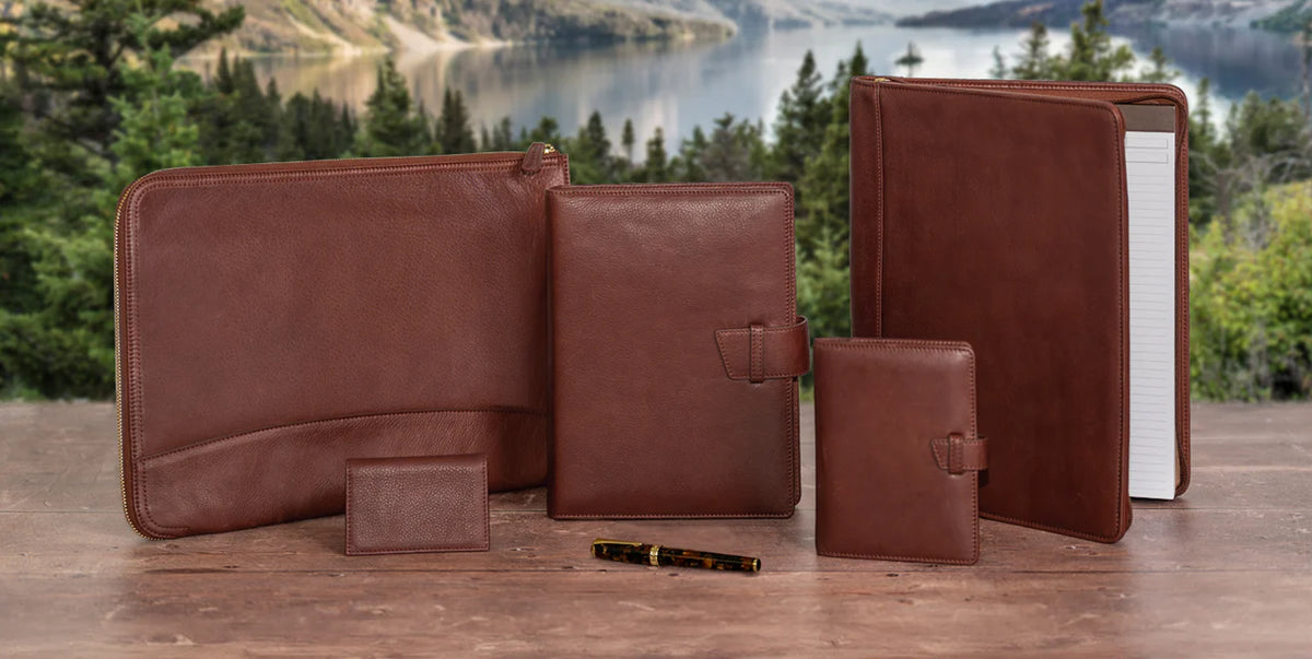 Five Levenger Circa notebooks—Jotlet, Compact, Junior, Midway, and Letter—stacked from smallest to largest with pages fanned to show disc binding.