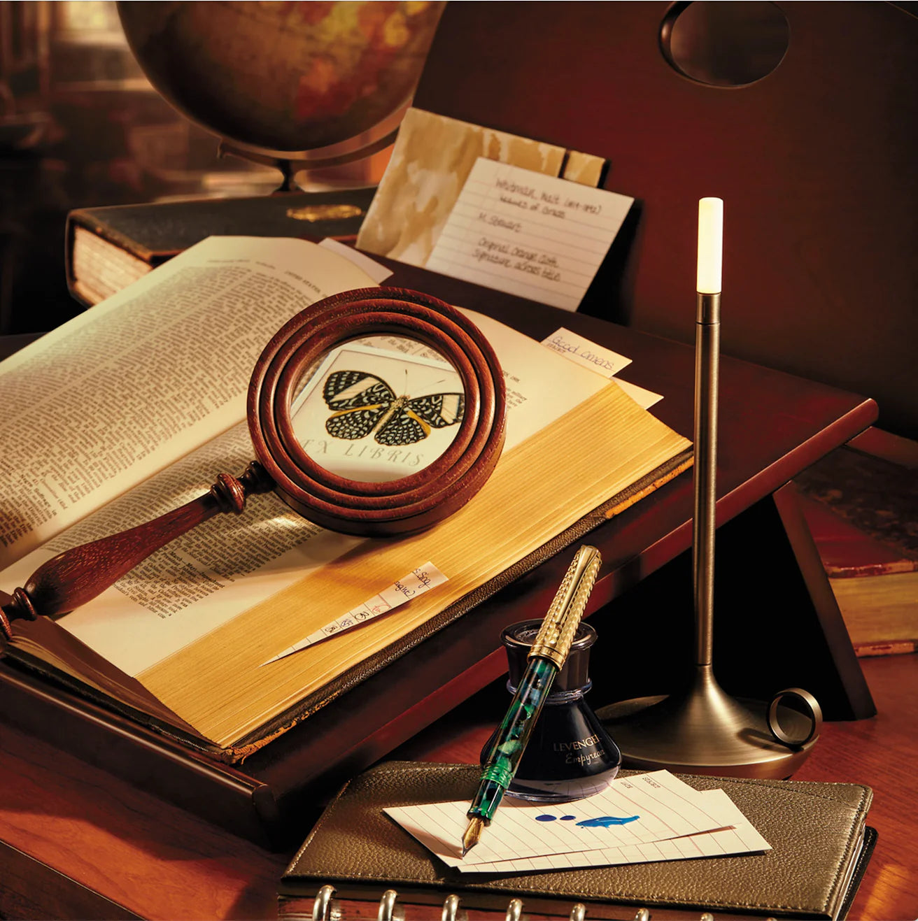 A left- and right-handed professional working side by side with Circa notebooks—one on a vertical weekly agenda spread, the other on a top-bound steno pad—showing ambidextrous, erg