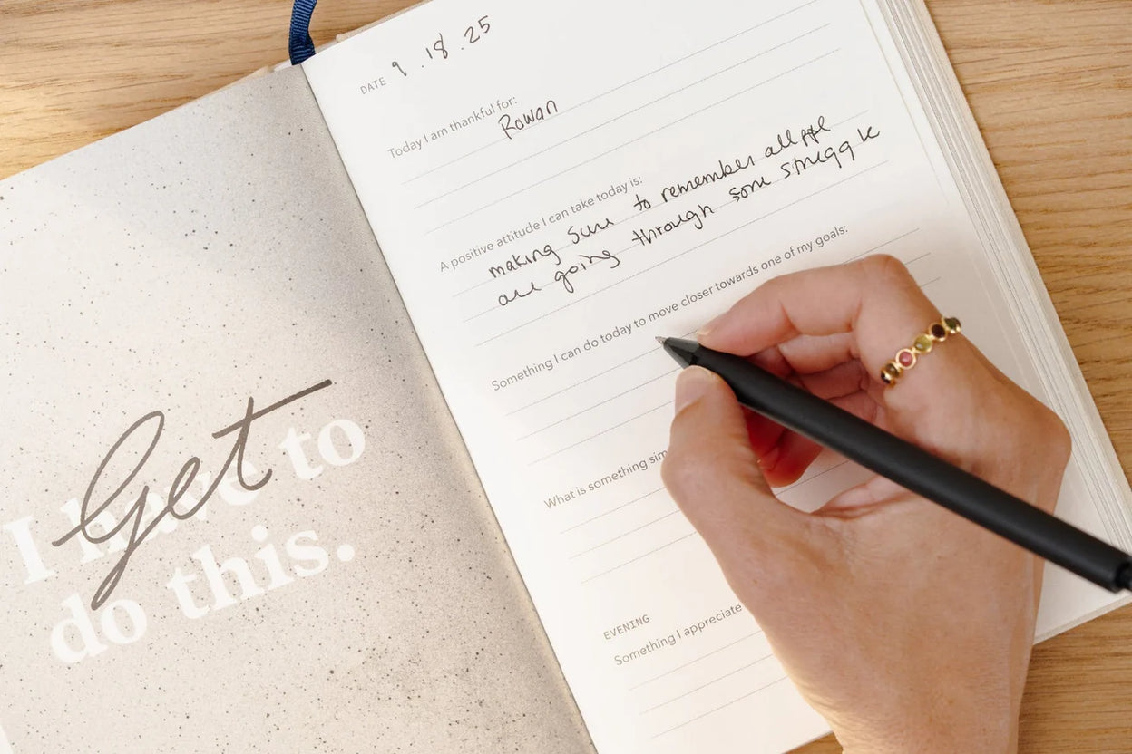 A Levenger Circa letter-size leather folio open on a desk beside a junior notebook, with aluminum discs and paper refills neatly arranged.