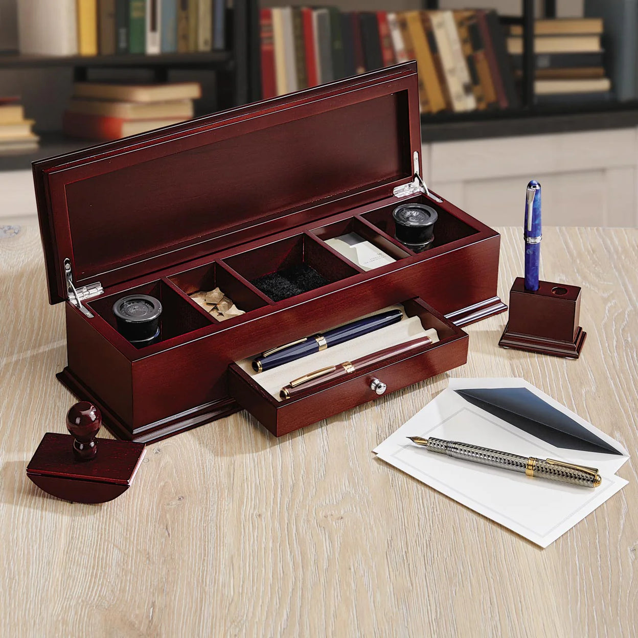 A ballpoint, rollerball, and fountain pen arranged on a Levenger notebook to show tip styles and finishes.
