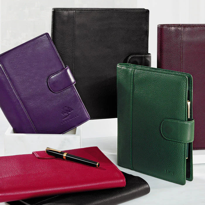 A Levenger Circa notebook open on a desk with archived pages neatly stacked beside color‑coded refills and discs ready for a quarterly swap.