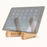 Birch wood tablet stand holding a rose gold tablet on a kitchen counter