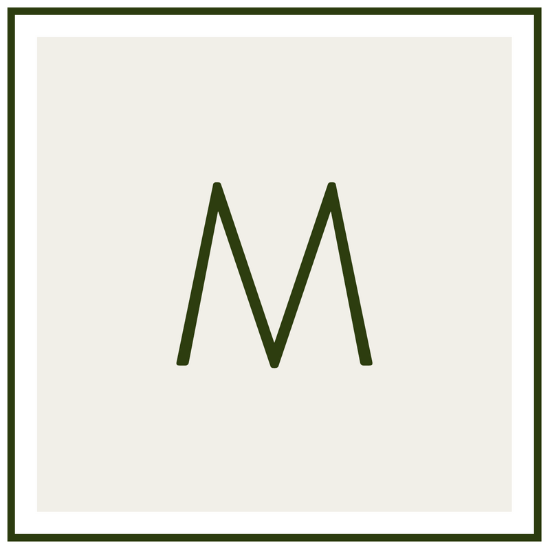 Monogram M in dark green on a pale beige background